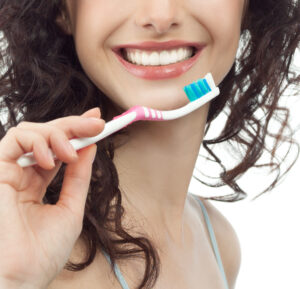 portrait of attractive caucasian smiling woman brunette isolated on white studio shot tooth brush
